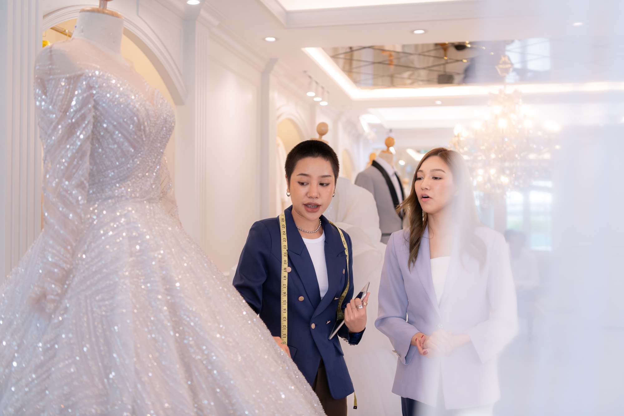 Both of asian fashion designers working with wedding dress in the wedding dress shop