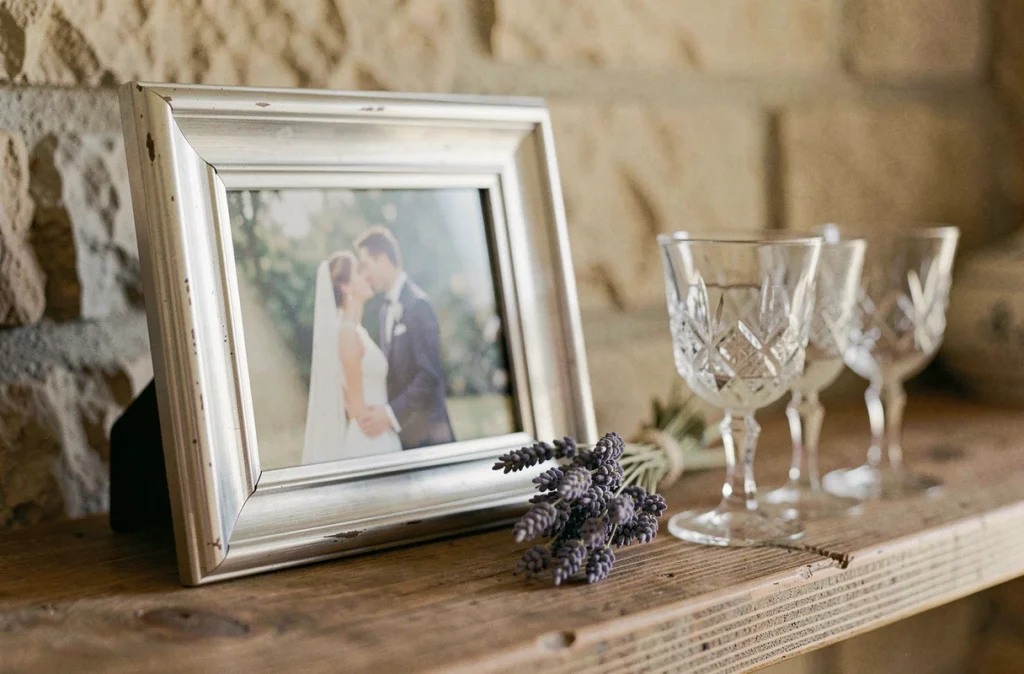 Photo encadrée d'un mariage posée sur une étagère en bois avec lavande séchée, évoquant un souvenir personnel intime